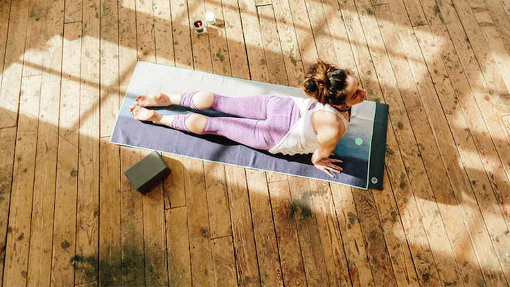 Woman lying on a yoga mat in a pose