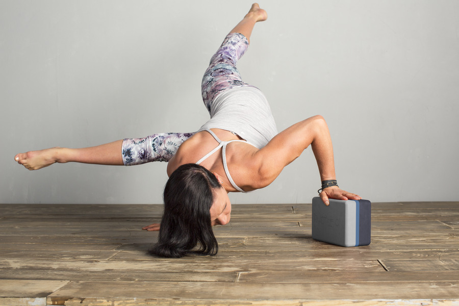 A yogi uses a block for extra balance during a pose